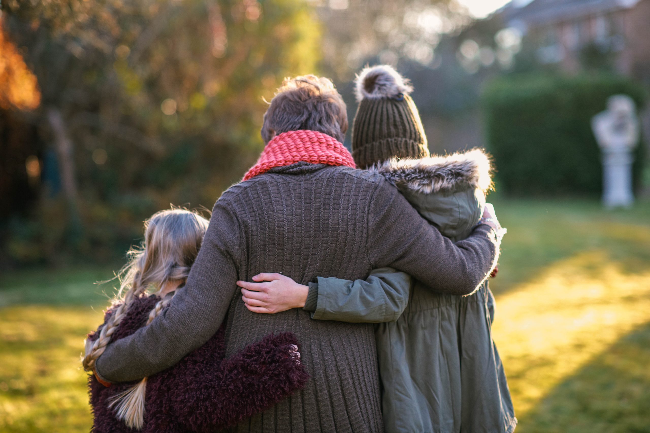 Grandmother and granddaughters hugging in garden